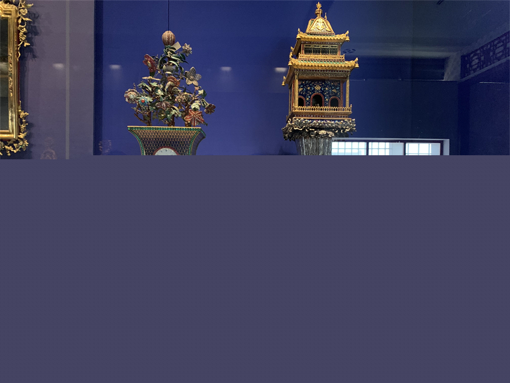 铜镀金嵌珐琅开花活蝶钟（左）和铜镀金嵌珐琅楼台式水法钟（右）